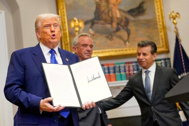 도널드 트럼프(왼쪽) 미국 대통령이 12일 워싱턴 백악관 루스벨트룸에서 자신이 서명한 미 약값 인하 관련 행정명령을 취재진에 들어 보이고 있다. 서명 행사에는 로버트 케네디 주니어(가운데) 보건복지부 장관과 마틴 마카리 식품의약국(FDA) 국장 등이 배석했다. 워싱턴=로이터 연합뉴스