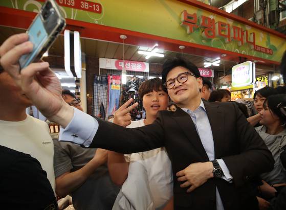 부산지역을 방문한 한 후보가 부평깡통시장에서 시민들과 사진을 촬영하는 모습. [뉴스1]