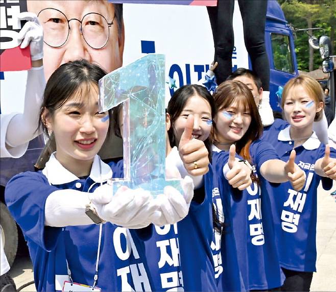 이재명 더불어민주당 대선 후보의 선거운동원들이 12일 경기 화성 유세에서 손가락으로 기호 1번을 표시하며 지지를 호소하고 있다.  강은구 기자