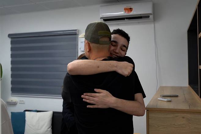 팔레스타인 무장단체 하마스로부터 석방된 이스라엘 미국 이중국적자 인질 에단 알렉산더가 12일 (현지시간)이스라엘의 한 장소에서 가족들과 재회하고 있다. UPI 연합뉴스