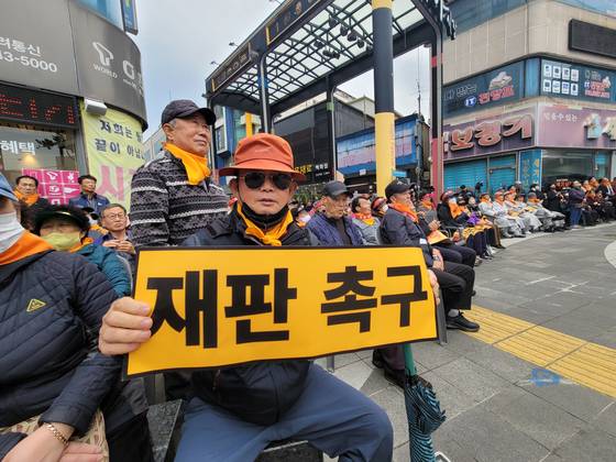 A participant holds a sign urging progress in the trial during a citizens' rally organized by the Pohang Earthquake Citizens' Countermeasure Headquarters and 120 social, religious and volunteer groups at Pohang Jungang Market in Pohang, North Gyeongsang, on Nov. 15, 2024. [NEWS1]