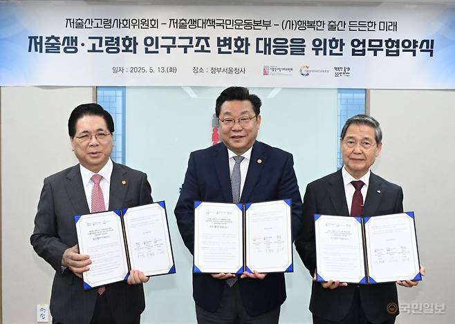 13일 서울 종로구 정부서울청사에서 진행된 저출생·고령화 인구구조 변화 대응을 위한 업무협약식에서 이영훈(왼쪽) 저출생대책국민운동본부 대표총재, 주형환(가운데) 저출산고령사회위원회 부위원장 감경철 (사)행복한출산든든한미래 이사장이 협약서를 들고 기념촬영을 하고 있다. 순복음교회 제공