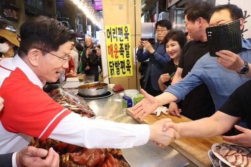 김문수 국민의힘 대선 후보가 13일 울산 남구신정시장을 찾아 상인, 시민과 인사하며 간식을 먹고 있다. 공동취재, 뉴시스