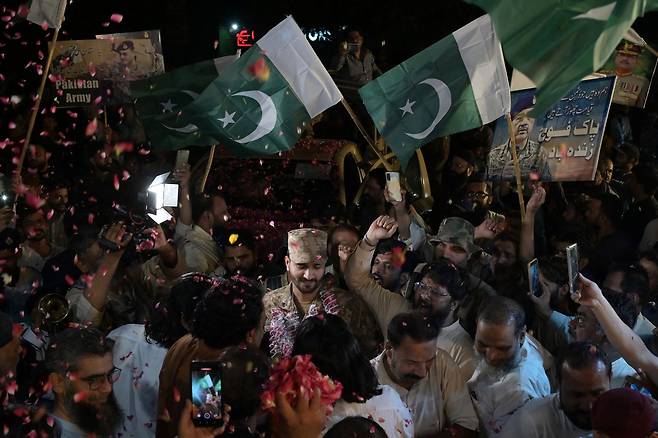 파키스탄 국민들이 12일(현지시간) 인도와 파키스탄의 무력 충돌이 벌어진 신드주 하이데라바드에서 양국이 휴전에 합의하자 군인들에게 꽃잎을 던지며 연대감을 표하고 있다. [AFP]