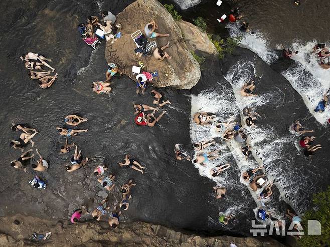 [피리베부이=AP/뉴시스] 19일(현지 시간) 파라과이 피리베부이의 살토스 델 피라레타 계곡에서 피서객들이 물놀이로 더위를 식히고 있다. 2025.01.20.