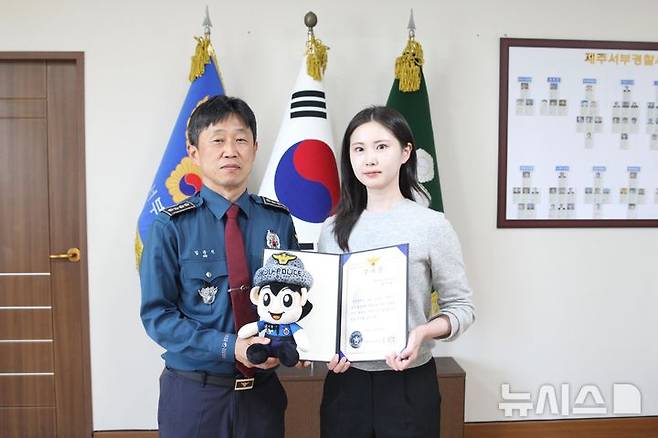 [제주=뉴시스] 김준식 제주서부경찰서장이 12일 청사에서 5000만원대 다단계 사기 범행을 예방한 제주은행 노형뉴타운지점 김시현 은행원에게 감사장을 수여하고 있다. (사진=제주서부경찰서 제공) 2025.05.13. photo@newsis.com