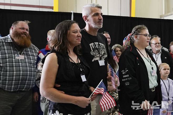 [덜레스=AP/뉴시스] 미국 국기를 든 남아프리카공화국계 아프리카너들이 12일(현지 시간) 미 버지니아주 덜레스에 있는 덜레스 국제공항에 도착하고 있다. 이날 아프리카너(16세기 이후 네덜란드 등 유럽에서 남아공으로 이주해 정착한 백인) 59명이 난민 자격으로 미국에 입국했다. 취임 뒤 사실상 난민 수용을 중단한 도널드 트럼프 행정부가 남아공 백인의 난민 지위를 인정해 미국 내 정착을 허용해 논란이 일고 있다. 2025.05.13.