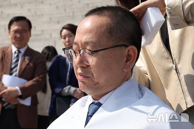 [서울=뉴시스] 조성봉 기자= 김문수 더불어민주당 의원이 11일 오후 서울 여의도 국회 본청 계단 앞에서 헌법재판소의 윤석열 대통령에 대한 조기 파면 결정을 촉구하며 삭발하고 있다. 2025.03.11. suncho21@newsis.com