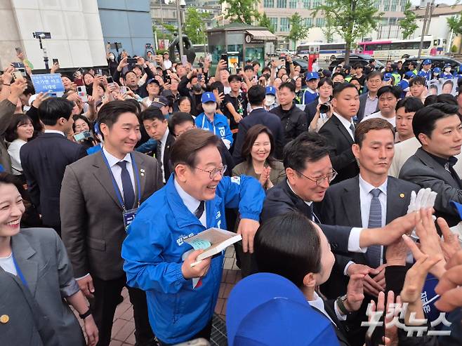 더불어민주당 이재명 후보가 13일 울산을 찾아 지지자들 책에 사인을 하고 있다. 이상록 기자