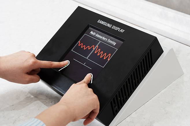 삼성디스플레이가&nbsp;13일(현지시간) 미국 새너제이 맥에너리컨벤션센터에서 열리는 ‘SID 2025’에 전시한 ‘센서 OLED 디스플레이’ 모습.&nbsp;화면 전체에서 지문을 인식하고, 빛으로 혈류량을 측정해 심혈관 건강 상태까지 확인할 수 있다.&nbsp; &nbsp; 삼성디스플레이 제공 &nbsp;