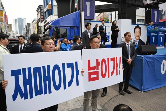 이재명 더불어민주당 대선 후보가 13일 대구 중구 동성로에서 유권자들에게 지지를 호소하고 있는 가운데 선거운동원들이 '재매이가 남이가!'라는 피켓을 들고 있다. 대구=오승현 기자 2025.05.13
