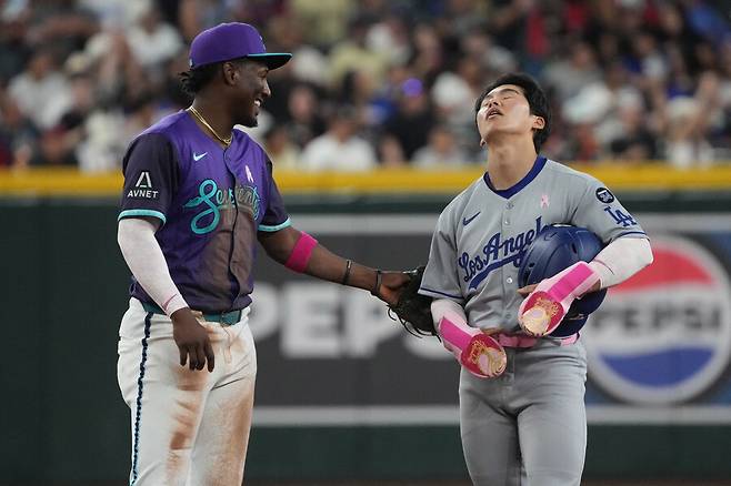 ▲세이프 판정이 챌린지를 통해 아웃으로 번복되자 아쉬워하는 김혜성. 애리조나 유격수 헤랄도 페르도모가 김혜성을 위로하고 있다. ⓒ연합뉴스/AFP