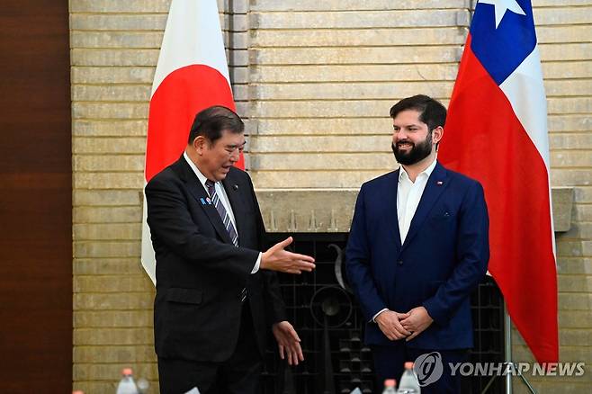 11일(현지시간) 도쿄를 찾은 보리치 칠레 대통령(오른쪽)에게 악수 청하는 이시바 일본 총리 [도쿄 로이터=연합뉴스. 재판매 및 DB 금지]