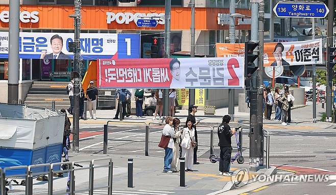 제21대 대선 선거운동 본격 시작 (서울=연합뉴스) 김도훈 기자 = 제21대 대통령선거 공식 선거운동 첫날인 12일 서울 마포구 홍대입구역 사거리에 더불어민주당 이재명 후보, 국민의힘 김문수 후보, 개혁신당 이준석 후보의 현수막이 걸려 있다. 2025.5.12 superdoo82@yna.co.kr