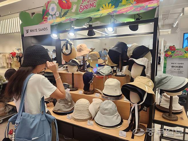 14일 스타필드 수원에서 고객이 여름 모자를 착용해보고 있다. 사진=이보현 기자