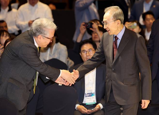 첫날인 14일 오전 개막식에 참석한 이명박 전 대통령이 고향 지인을 만나 반갑게 악수하고 있다.