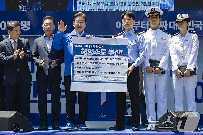 이재명 더불어민주당 대통령 후보가 민주당 험지로 꼽히는 부산·경남(PK) 지역 유세에 나선 14일 부산 부산진구 서면에서 권기흥 에이치라인해운해상직원노조 위원장과 해양수도 부산 협약서에 서명한 뒤 기념 촬영하고 있다. (공동취재) 2025.5.14/뉴스1 ⓒ News1 안은나 기자