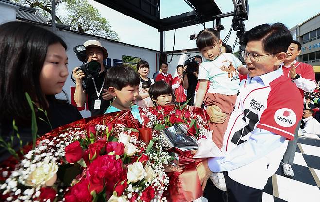 김문수 국민의힘 대통령 후보가 14일 경남 밀양시 밀양관아 앞에서 열린 유세에서 정용우, 손정혜 씨의 육남매 자녀들에게 꽃을 전달 받고 있다. /뉴스1