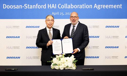 박지원(왼쪽) 두산그룹 부회장과 제임스 랜데이 스탠포드 대학 HAI 연구소 공동연구소장이 지난달 25일 동대문 두산타워에서 열린 산학협력 협약식에서 기념사진을 촬영하고 있다. 두산 제공