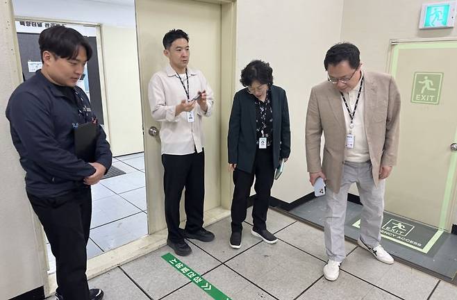 최근 부산시설공단과 부산디자인진흥원이 백양터널의 공공디자인 개선에 나선 가운데 두 기관 관계자들이 백양터널 관리지소 출입구 바닥을 둘러보며 안전디자인 상태를 확인하고 있다. 부산시설공단 제공