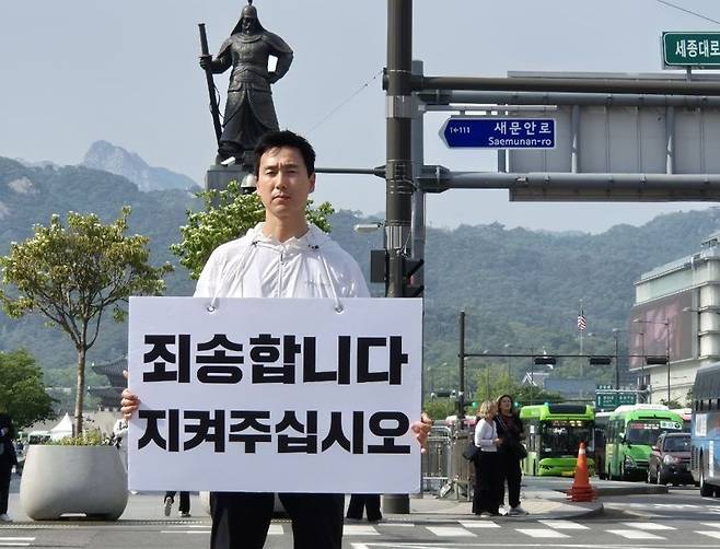 김기흥 전 국민의힘 대변인이자 전 대통령실 부대변인이 14일 서울 광화문 광장 앞에서 '죄송합니다. 지켜주십시오'라는 팻말을 들고 침묵의 사죄를 하고 있다.