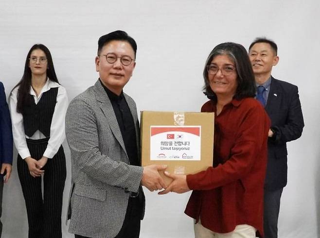 신훈 희망브리지 사무총장(왼쪽)이 튀르키예 임시주거시설 생활 이재민에게 위생키트를 전달하고 있다. 희망브리지 제공