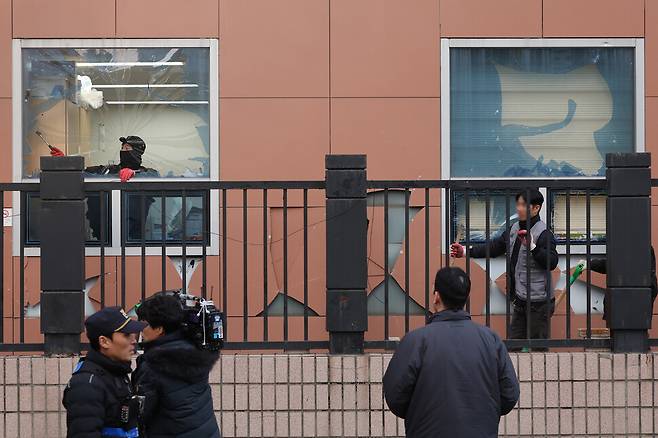 내란죄 피의자 윤석열 전 대통령의 구속 영장이 발부되자 윤 대통령의 지지자들이 서울 마포구 서울서부지법에 난입해 기물과 유리창 등을 파손한 1월19일 오후 건설업자가 깨진 창문의 유리를 제거하고 있다. 김영원 기자 forever@hani.co.kr