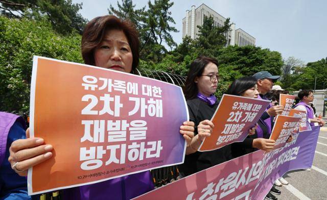 14일 서울 서초구 서울중앙지법 앞에서 열린 '10·29 이태원참사 2차 가해한 김미나 경남 창원시의원에 대한 손해배상 소송' 기자회견에서 유가족들이 손팻말을 들고 있다. 연합뉴스