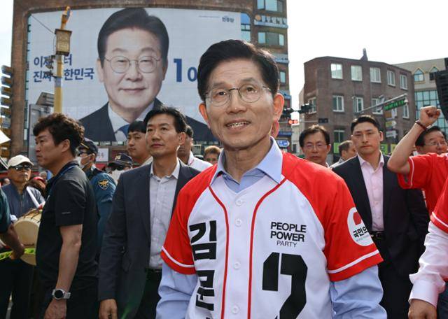 김문수 국민의힘 대선 후보가 14일 경남 밀양시 밀양관아 앞에서 유세를 마치고 차량으로 이동하고 있다. 김 후보 뒤로 이재명 더불어민주당 대선 후보의 현수막이 보이고 있다. 밀양=하상윤 기자