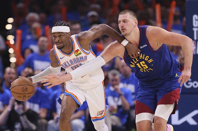 <yonhap photo-6297=""> Oklahoma City Thunder's Shai Gilgeous-Alexander, left, advances the ball upcourt under pressure from Denver Nuggets center Nikola Jokic (15) in the second half of Game 5 of an NBA basketball second-round playoff series Tuesday, May 13, 2025, in Oklahoma City. (AP Photo/Nate Billings)/2025-05-14 12:43:01/ <저작권자 ⓒ 1980-2025 ㈜연합뉴스. 무단 전재 재배포 금지, AI 학습 및 활용 금지></yonhap>