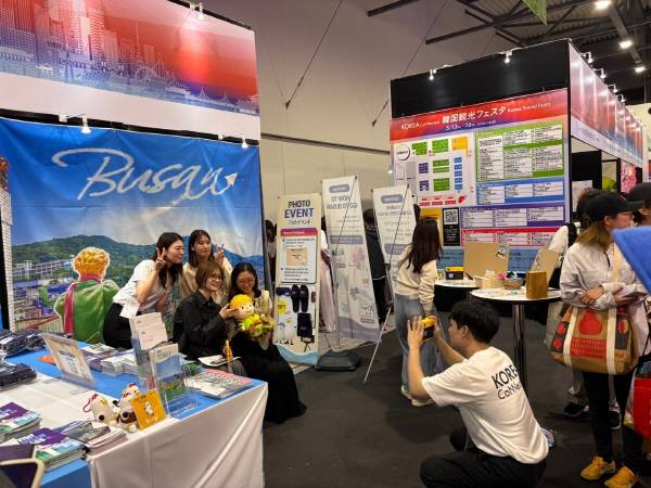 지난 13일 오사카 엑스포에 마련된 부산 관광 홍보 부스에서 방문객들이 감천문화마을 포토존을 배경으로 기념 촬영을 하고 있다. 부산관광공사 제공