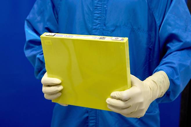 An employee holds a full-size prototype lithium manganese-rich (LMR) battery cell at the General Motors Wallace Battery Cell Innovation Center. [GENERAL MOTORS]