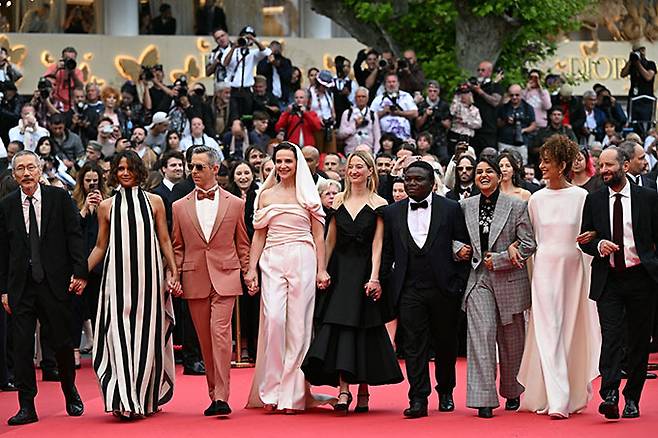 (사진 왼쪽부터) 영화감독 홍상수가 배우 할리 베리, 제레미 스트롱, 줄리엣 비노쉬, 알바 로르바체르, 콩고 출신 영화감독 디웨도 아마디, 인도 출신 영화감독 파얄 카파디아, 프랑스 출신 작가 레일라 슬라마니, 멕시코 출신 영화감독 카를로스 레이디가스 등 제78회 칸 국제 영화제 심사위원단과 함께 개막전 레드카펫 행사에 참석했다./AFPBBNews=뉴스1