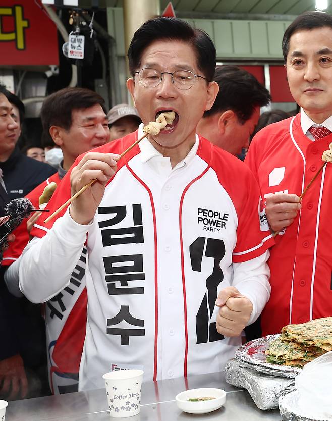 국민의힘 김문수 대선 후보가 14일 경남 진주시 진주중앙시장을 방문해 어묵을 먹고 있다. <연합>