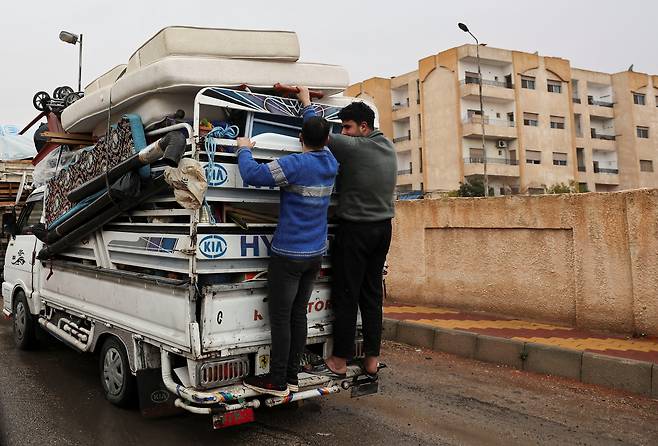 시리아의 전직 군인들이 기아 봉고 차량을 통해 짐을 적재하고 있다. 차량 뒷편에 현대차와 기아 마크가 새겨져 있다. [로이터]