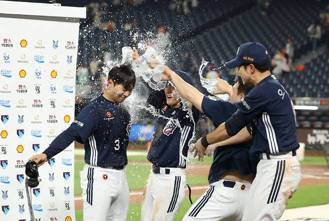 두산 임종성(왼쪽)이 13일 한화와 원정에서 연장 11회초 결승타를 때려 팀 승리를 이끈 뒤 인터뷰에서 동료들의 축하 물 세례를 받고 있다. 두산