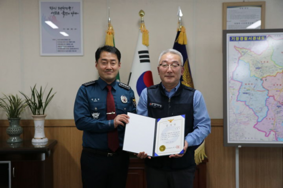 성추행범 검거 기여한 버스 기사 - 버스 안 성추행범을 검거하는 데 기여한 버스기사 이권우(56·오른쪽)씨가 지난 8일 부산 기장경찰서에서 감사장과 112신고 포상금을 받은 뒤 기념 촬영을 하고 있다.  부산 기장경찰서 제공