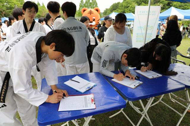 ▲ 충북보건과학대학교 덕암축제가 열린 15일 재학생들이 청주공항 민간전용활주로 건설 촉구 서명을 하고 있다./충북보건과학대 제공