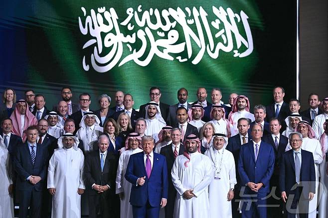 도널드 트럼프 미국 대통령과 무함마드 빈 살만 사우디아라비아 왕세자가 13일(현지시간) 리야드에서 열린 '사우디·미국 투자 포럼' 중 참석자들과 포즈를 취하고 있다. 2025.05.14 ⓒ AFP=뉴스1 ⓒ News1 우동명 기자