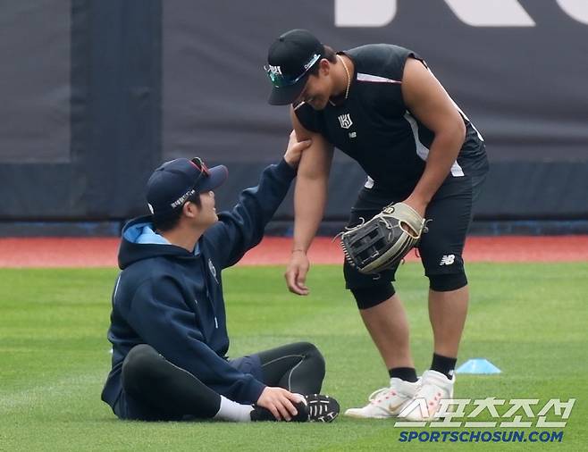 안현민을 부른 한현희가 우람한 팔을 만져보고 있다.