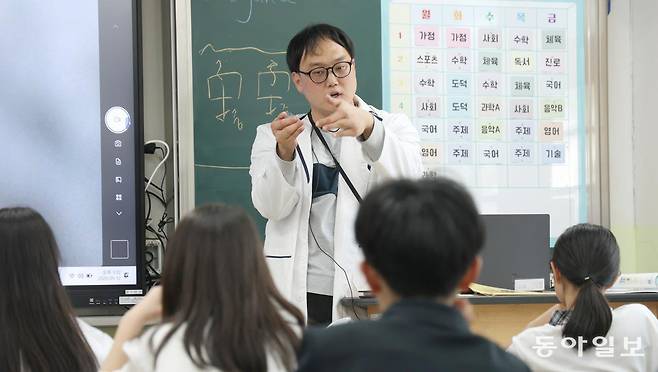 12일 오후 서울 금천구 한울중학교 1학년 1반 교실에서 과학 교사 김한음 씨가 부력의 원리에 대해 설명하고 있다. 김 씨는 선천적으로 양손에 손가락이 각각 4개인 지체장애 3급 중증장애인이다. 변영욱 기자 cut@donga.com