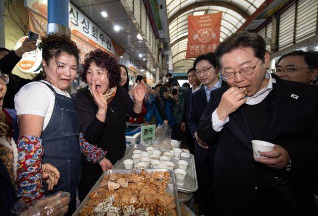 이재명(오른쪽) 더불어민주당 대통령 후보가 10일 경남 사천시 사천읍시장에서 과자를 맛보고 있다. 뉴스1