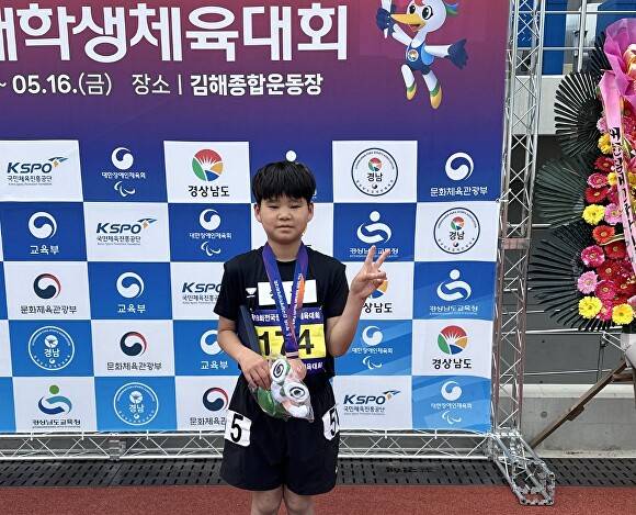 이상민 청주용담초 현양원분교 학생이 전국장애학생체육대회에서 받은 메달을 목에 걸고 포즈를 취하고 있다. [사진=청주교육지원청]