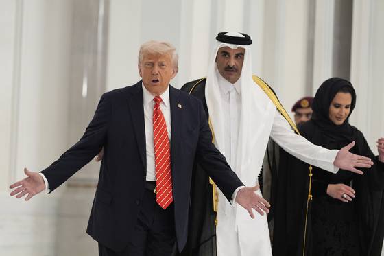 도널드 트럼프 미국 대통령(왼쪽)과 셰이크 타밈 하마드 알 타니 카타르 국왕이 14일(현지시간) 카타르 도하의 루사일 궁에 마련된 국빈 만찬장에 들어서고 있다. AP=연합뉴스