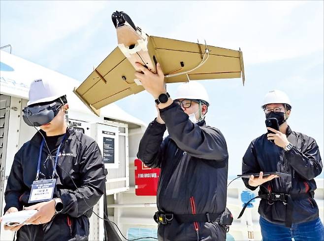 < ‘자폭 드론’ 날리는 해군 > 해군이 지난 13일 울산 일산항 인근 해상에서 실시한 훈련에 참가한 민간 요원이 골판지 자폭드론 비행을 준비하고 있다.  /사진공동취재단