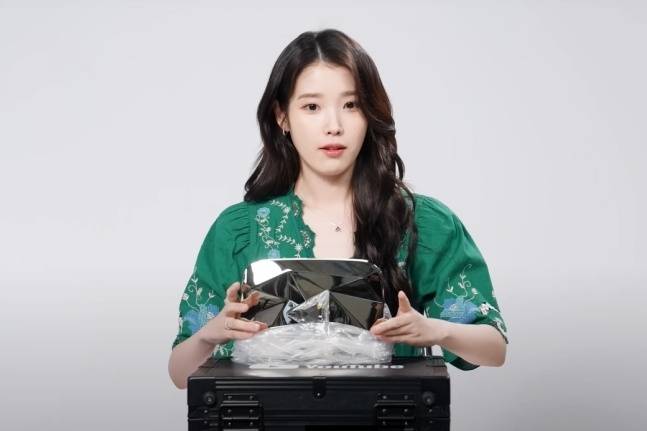 아이유가 채널 구독자 1000만명을 달성해 다이아 버튼을 받아 공개하고 있다.  [사진, 유튜브 ‘이지금’ 채널 캡처]