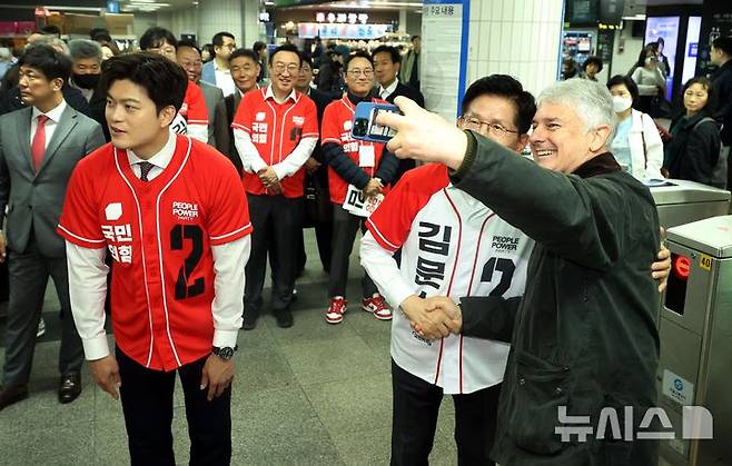 [서울=뉴시스] 조성봉 기자=김문수 국민의힘 대선후보가 15일 오전 서울 구로구 신도림역에서 한 외국인과 셀카를 찍고 있다.  왼쪽은 김용태 공동선대위원장. 2025.05.15. suncho21@newsis.com