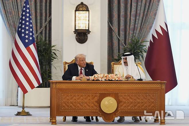 [도하=AP/뉴시스] 도널드 트럼프 미국 대통령이 14일(현지 시간) 카타르 도하에서 타밈 빈 하마드 알사니 국왕과 회담하고 있다. 2025.05.15