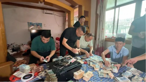푸저우시 공안국 경제범죄수사대가 위조지폐를 제작해 유통한 부부의 집을 수색하며 돈뭉치를 확인하고 있다.