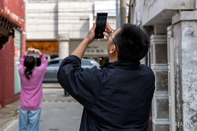 고립·은둔 청년들의 자조 모임터 ‘두더집’에서 열린 ‘사진 치유 워크숍’ 강사 박상은씨(왼쪽)와 수강생 우기씨(오른쪽)가 골목길에서 촬영을 하고 있다. ⓒ시사IN 신선영